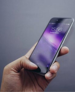 Person using iPhone with purple background vertical