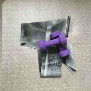 Image shows purple hand weights and a pilates resistance band