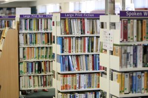 Image shows large print edition books on library shelves