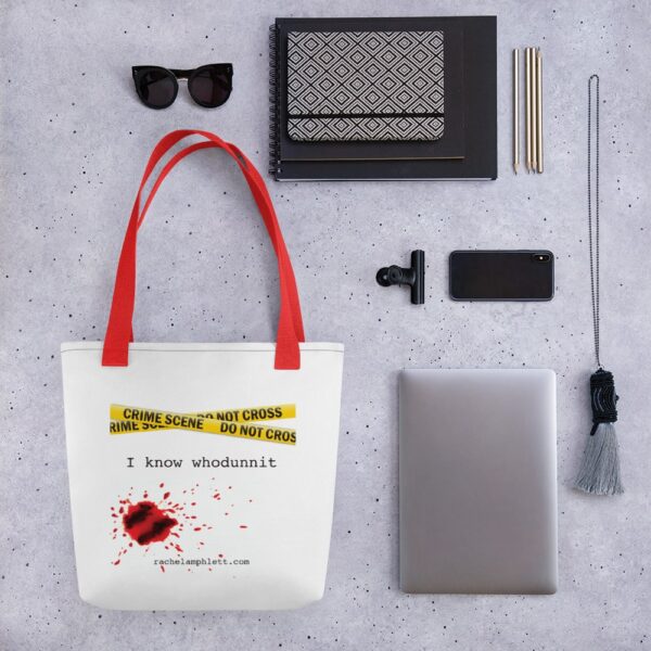 Image shows tote bag with red strap and yellow crime scene tape with the words I Know Whodunnit underneath and blood spatter
