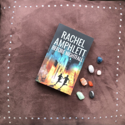 Before Nightfall book resting on a brown velvet background