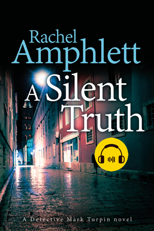 Cover shows a narrow English cobblestoned alleyway in the rain at night and a sticker depicting an audiobook